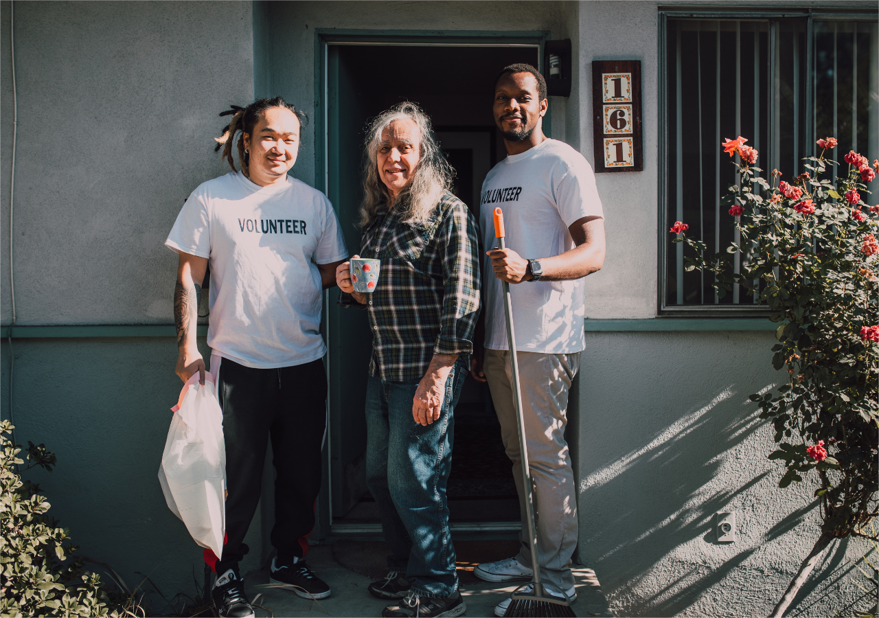 2 volunteers from a nonprofit organize are helping a old person.