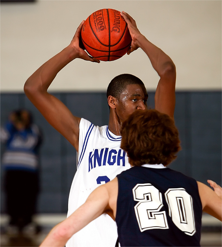 A college athlete is playing basketball.