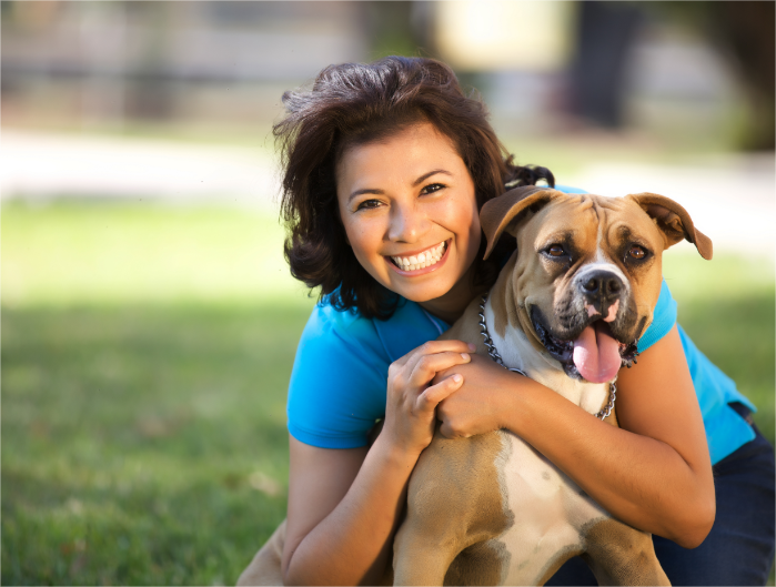 A volunteer hugging a dog in a fundraising event.