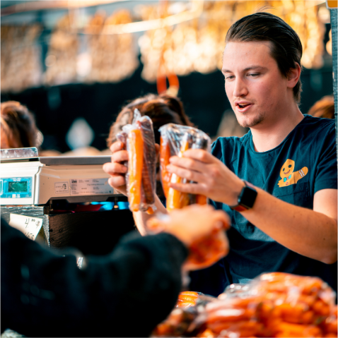 A man is handing food at a food fundraising event.